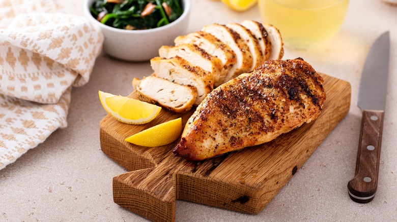 Sliced grilled chicken on cutting board