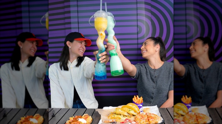 Two friends sharing boozy drinks and an array of food at Taco Bell cantina.