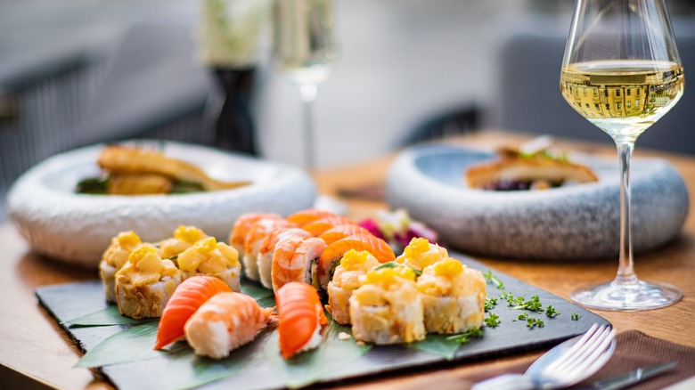 white wine with a plate of different sushi
