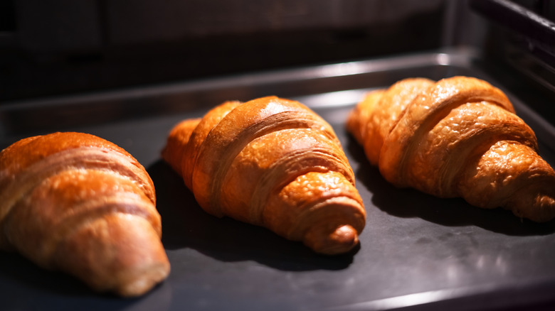 Three croissants bake in an oven
