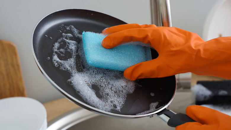A person cleaning a pan.