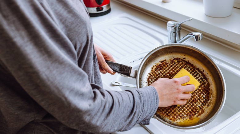 Person cleaning a greasy pan
