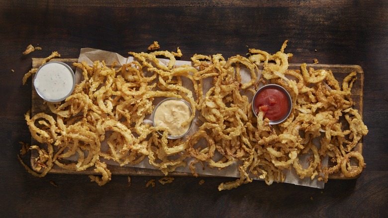 Platter of fried onions with dipping sauces