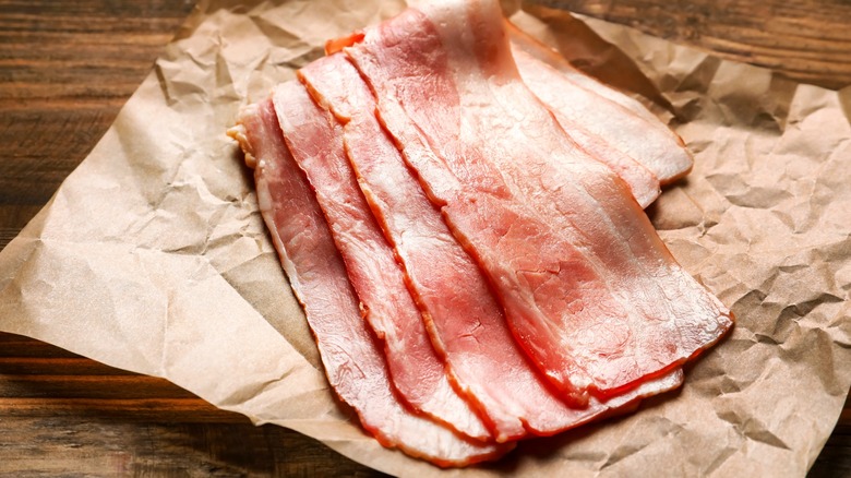 raw bacon on parchment paper