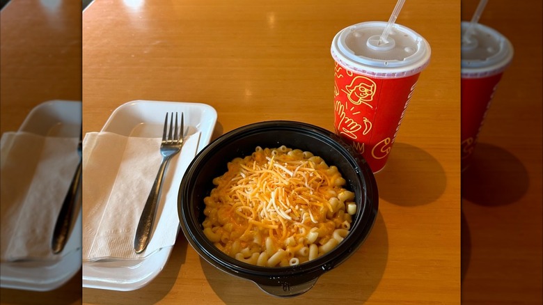 A bowl of noodles with shredded cheese on top from Noodles & Company