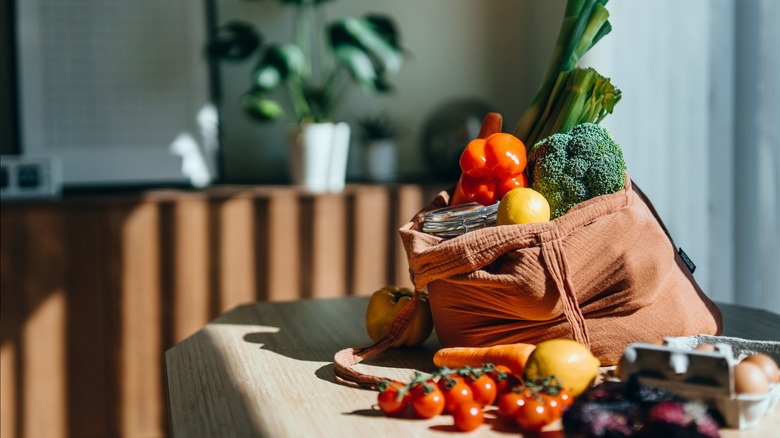 A reusable shopping bag full of produce