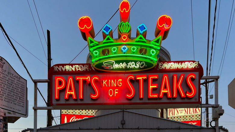 Neon Pat's King of Steaks sign with a crown in red, yellow, and blue