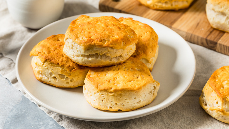 Four buttermilk biscuits on a white plate.
