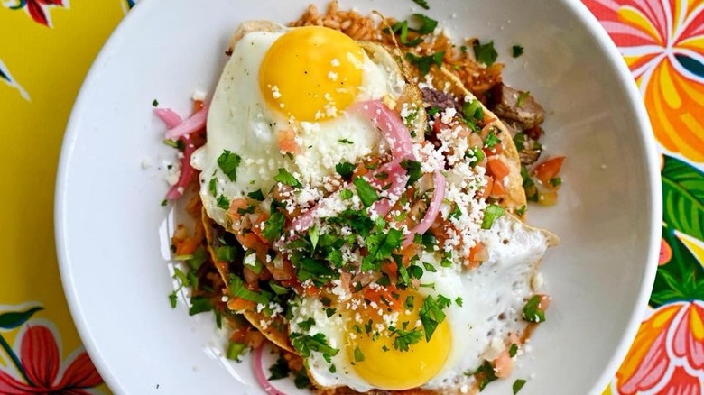 Huevos rancheros topped with chile-tomato sauce, herbs, and chiles.
