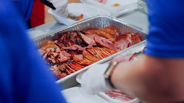 Smithfield Foods employees prepare meals with ham from a roasting pan
