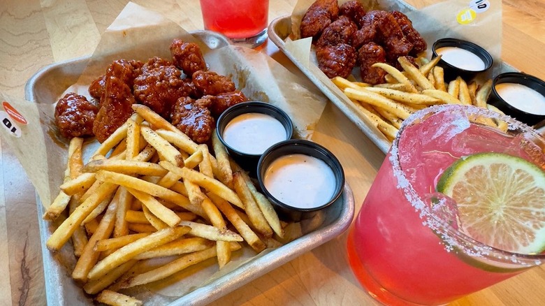 Buffalo Wild Wings meals with fries, wings, and two dips, with two pink drinks