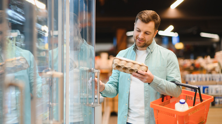 shopper taking eggs from fridge
