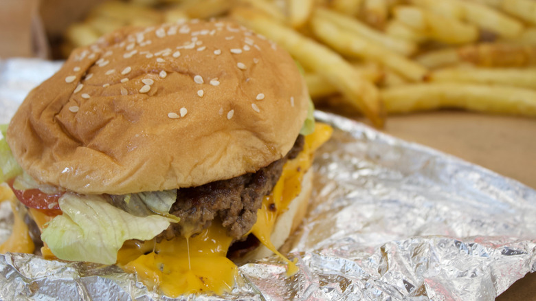 A burger from Five Guys sitting on foil.