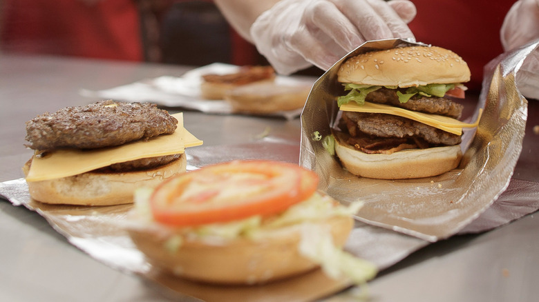 A double cheeseburger being wrapped at Five Guys.
