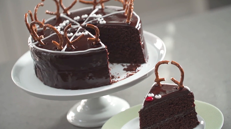 Chocolate ganache reindeer cake and slice decorated with pretzels and candy eyes