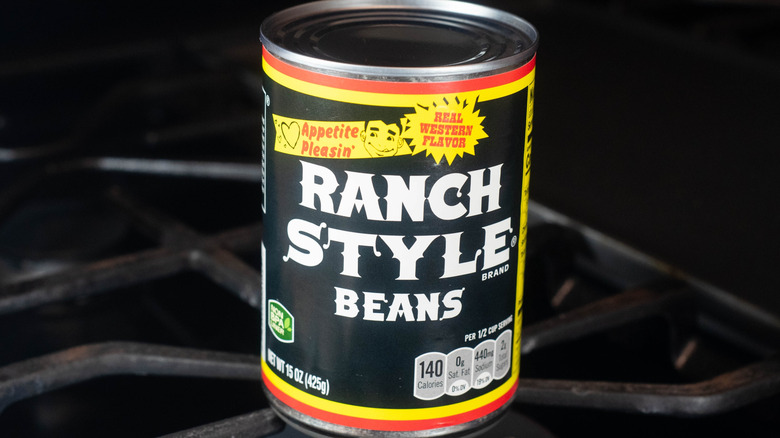 A can of Ranch Style Beans on a stovetop.