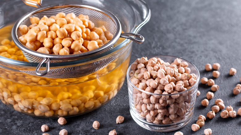 Dried chickpeas in a bowl, soaked beans in pot with aquafaba water