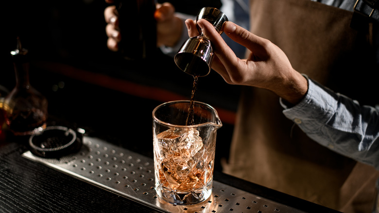 bartender pouring alcohol from jigger
