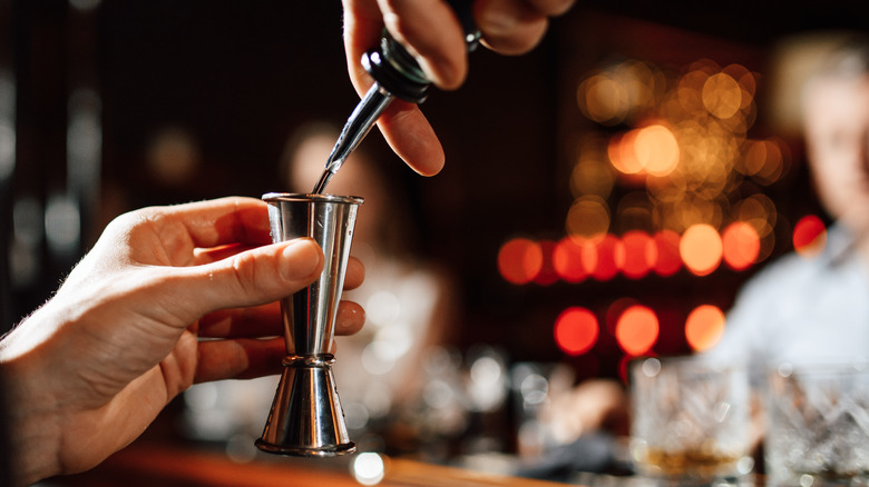 pouring alcohol into a jigger