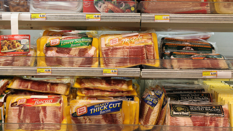 packages of bacon on grocery store shelves