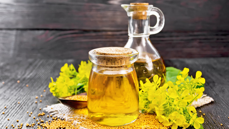 containers of mustard oil with seeds and flowers