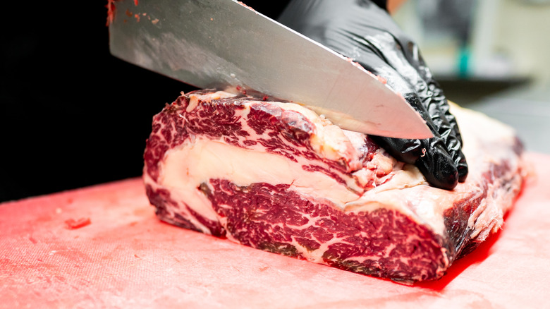 Chef slicing steaks from a whole roast