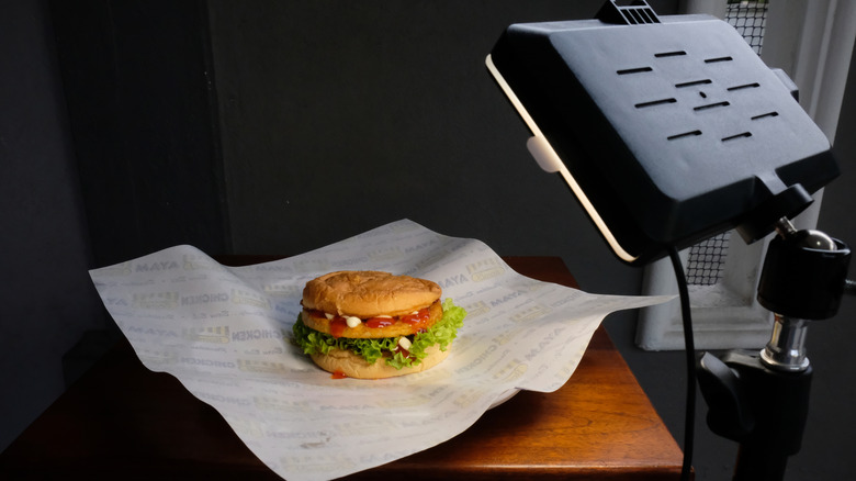 Food photoshoot shows chicken burger being professionally lit