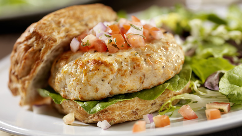 Homemade turkey burger on a bun with salsa and salad
