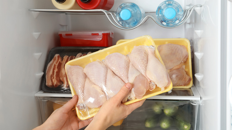 pulling raw chicken from fridge