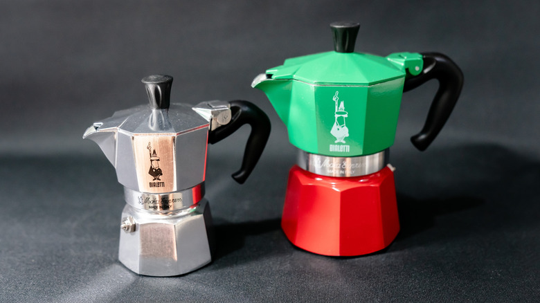Large green and red Moka espresso pot next to a small metal one