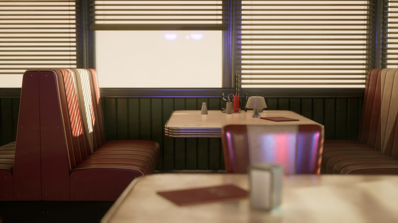 A retro diner with booths and tables is bathed in early or late sunlight