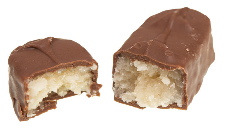 A Mounds bar split in half to reveal the coconut filling.