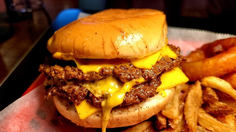 Cheese dribbles off of a double burger.