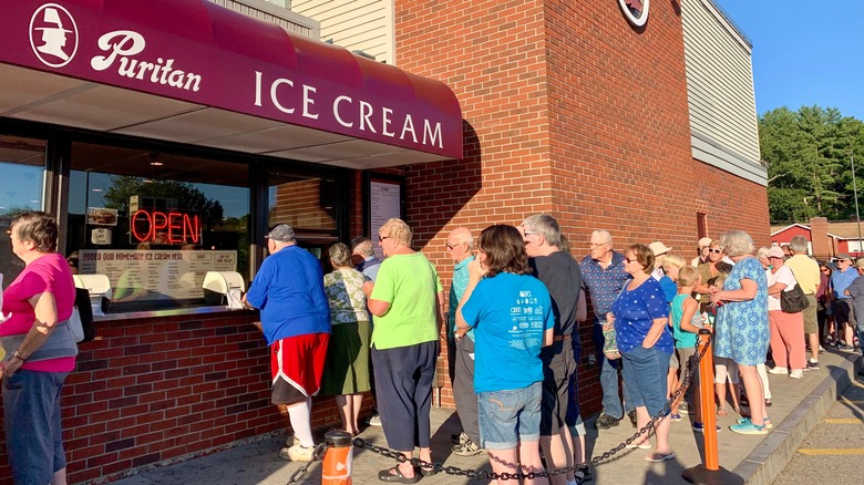 Customers stand in a long outdoor line to order ice cream at Puritan in New Hampshire