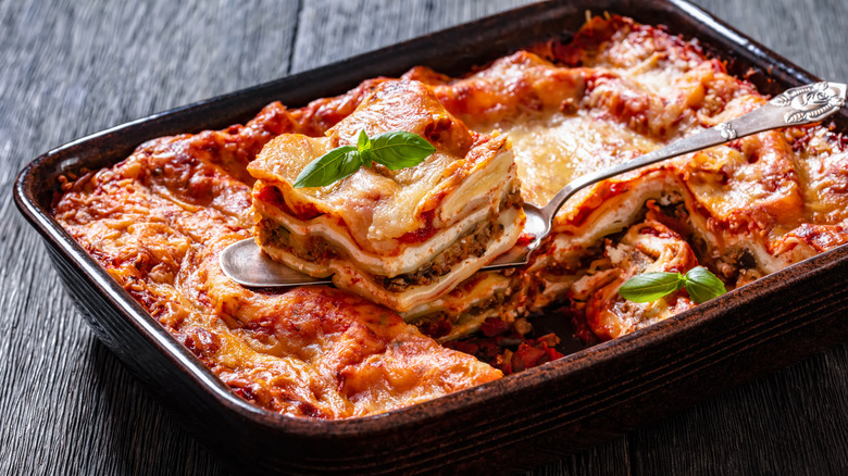 Pan of lasagna with one portion scooped out