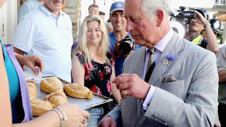 King Charles III examines pastries