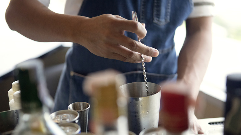 Stirring cocktail with bar spoon