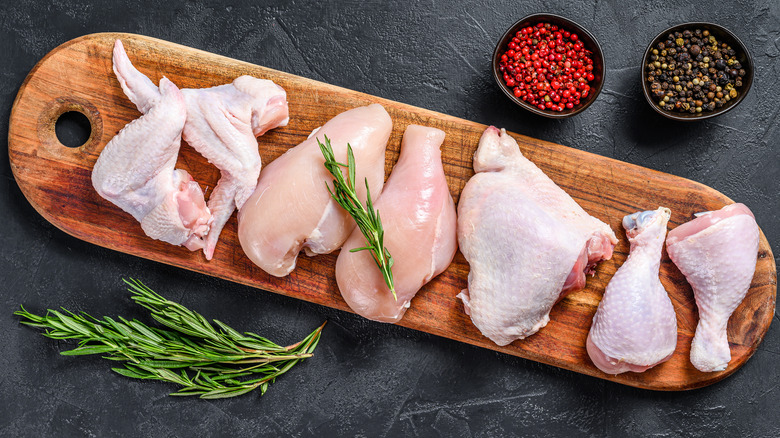 Individual cuts of raw chicken on cutting board