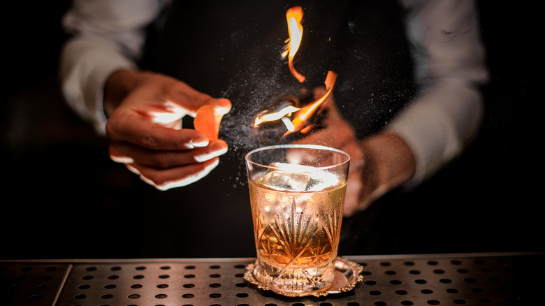 Bartender torching orange zest