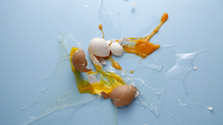 dropped raw eggs on a blue surface