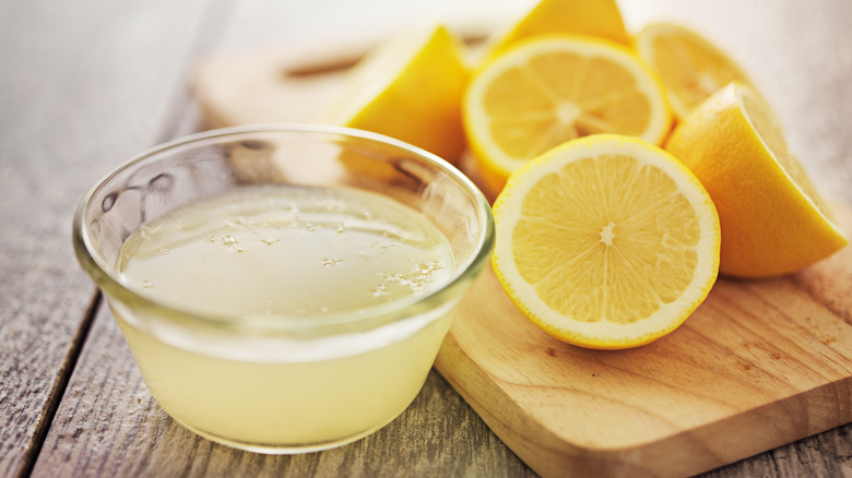 cut lemons next to bowl of clemon juice