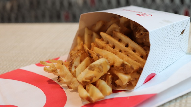 A serving of Chick-Fil-A waffle fries sitting on top of a to-go bag