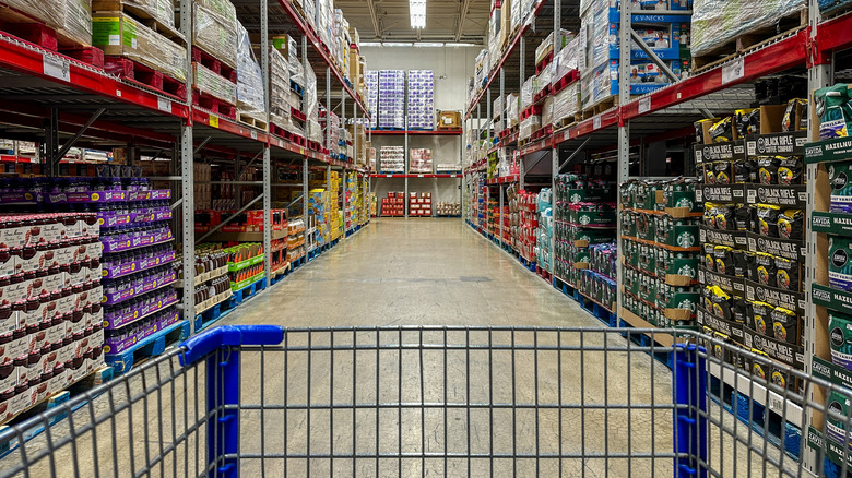 A shopping cart waits at the front of a Sam's Club aisle