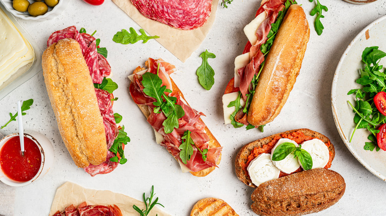 A variety of sandwiches and ingredients on a stone table