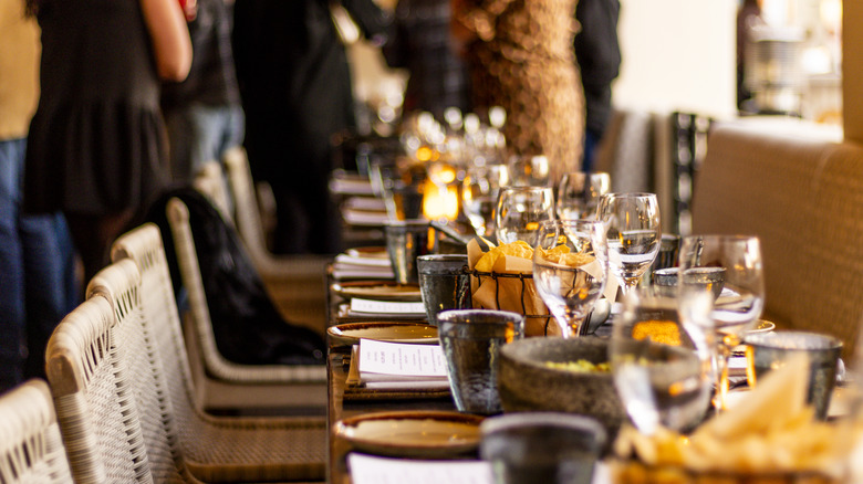 A long dining table set with tableware.