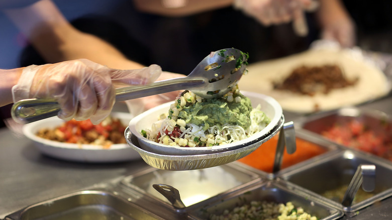 Employee making a Chipotle bowl