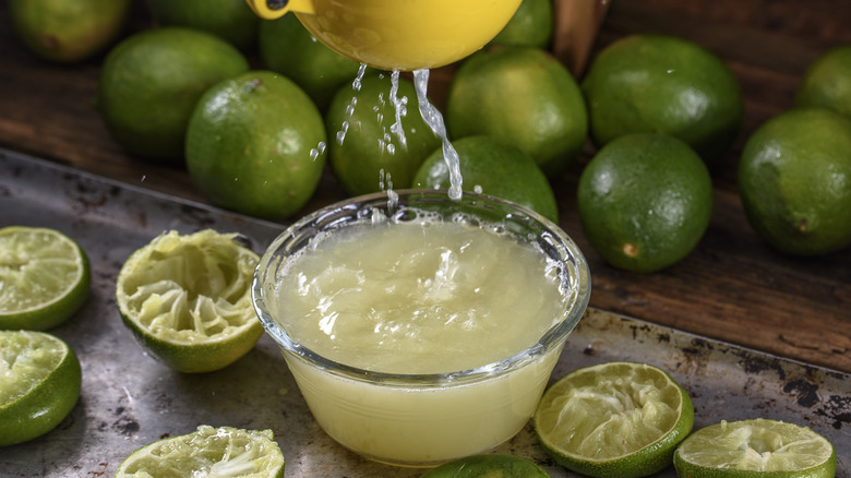 Lime juice being squeezed into a bowl