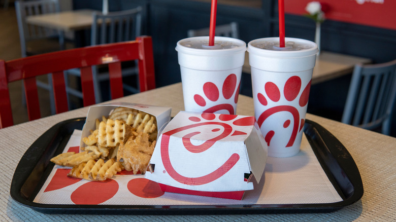 Chick-fil-A waffle french fries next to a sandwich and drinks