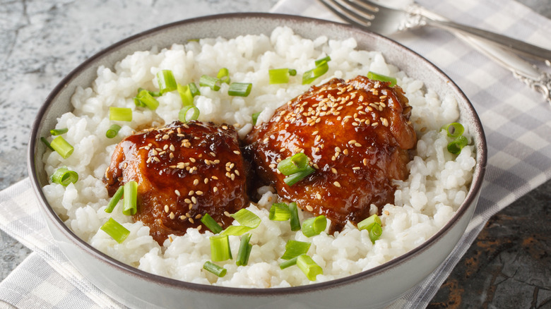 Hawaiian chicken shoyu in a bowl of rice topped with sesame and chives