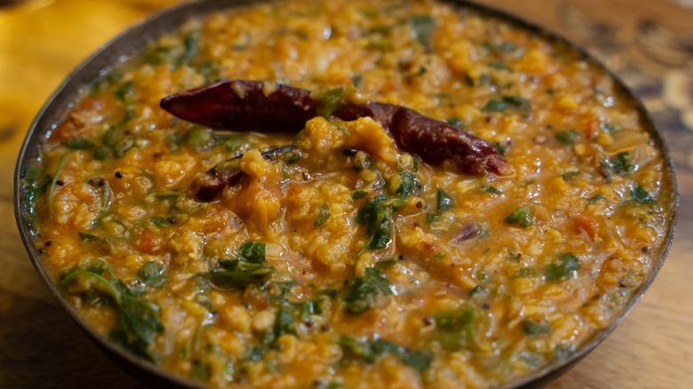 Bowl of Indian yellow daal with spices and herbs